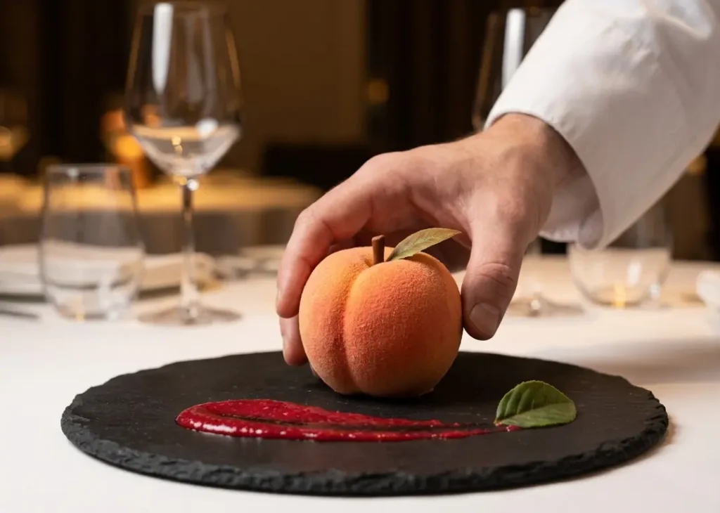 artisan cake plated for fine dining service — fruit-shaped dessert on slate